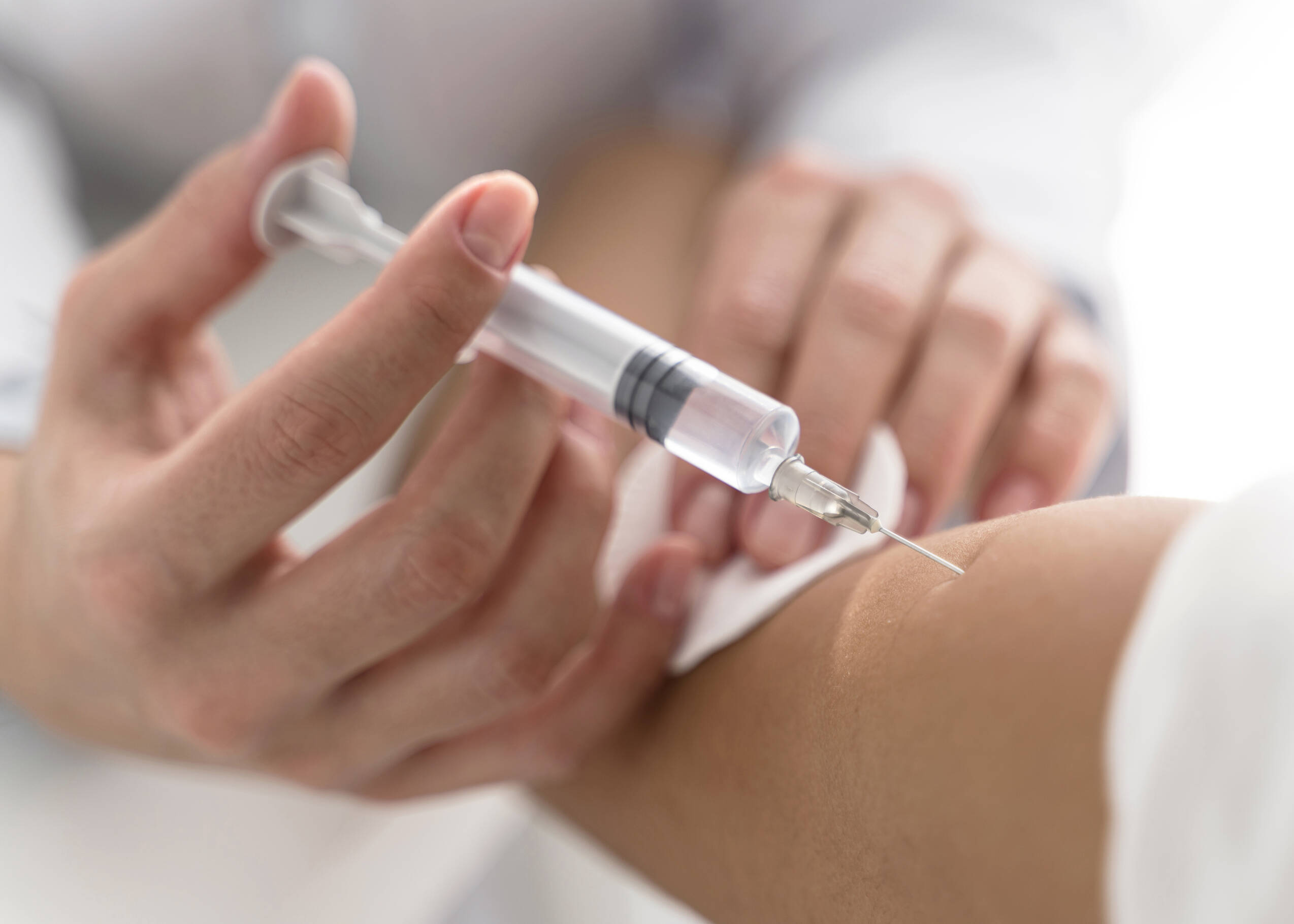 High angle doctor injecting vaccine patient